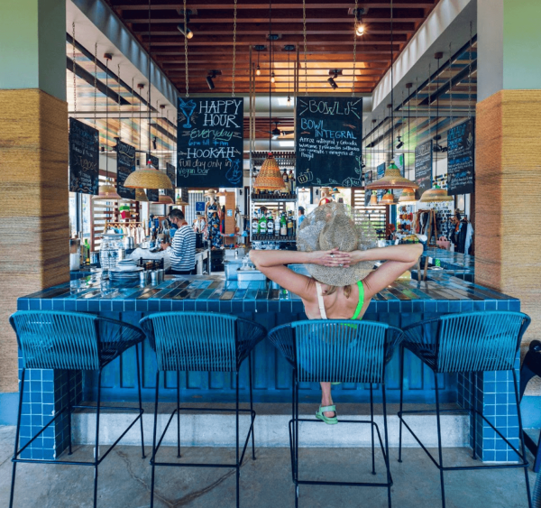 open-air vegan bar serves woman fresh smoothie